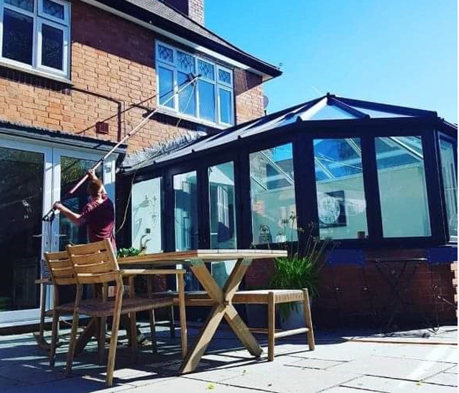 Window cleaning over a conservatory roof.